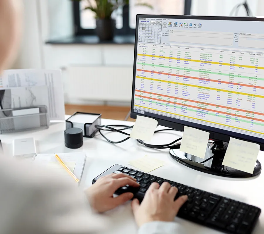 Person using BinManager skip bin scheduling and tracking software on a desktop monitor.